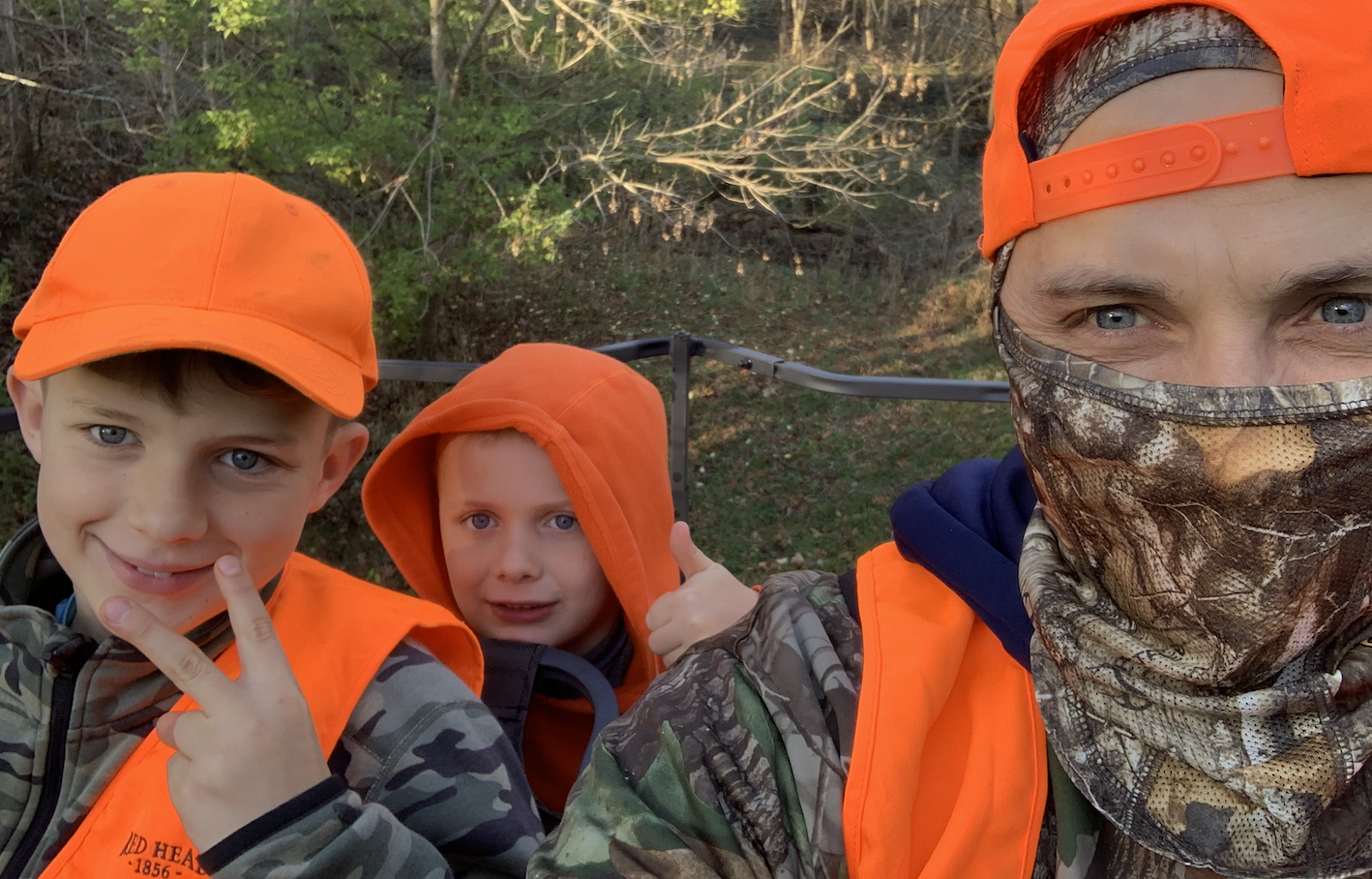 Tommy in the deer stand with two of his boys in blaze orange