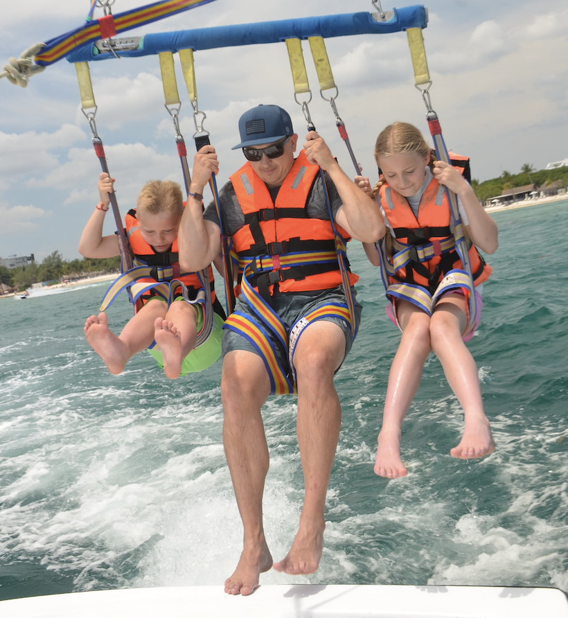 Tommy and his kids skimming the water at the end of a parasail ride